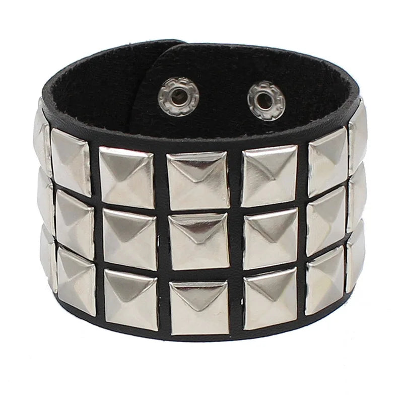 Black PU leather cuff covered in three rows of silver pyramid studs on a wide band.