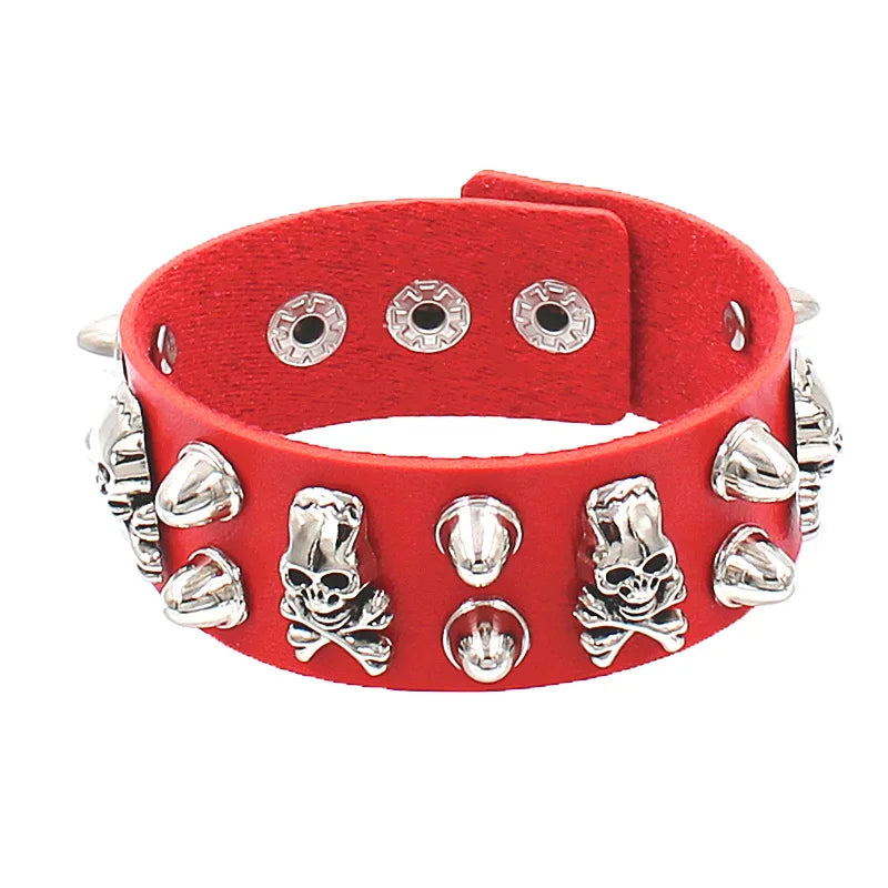 Red PU leather cuff with silver skull-and-crossbones studs alternating with cone spikes.