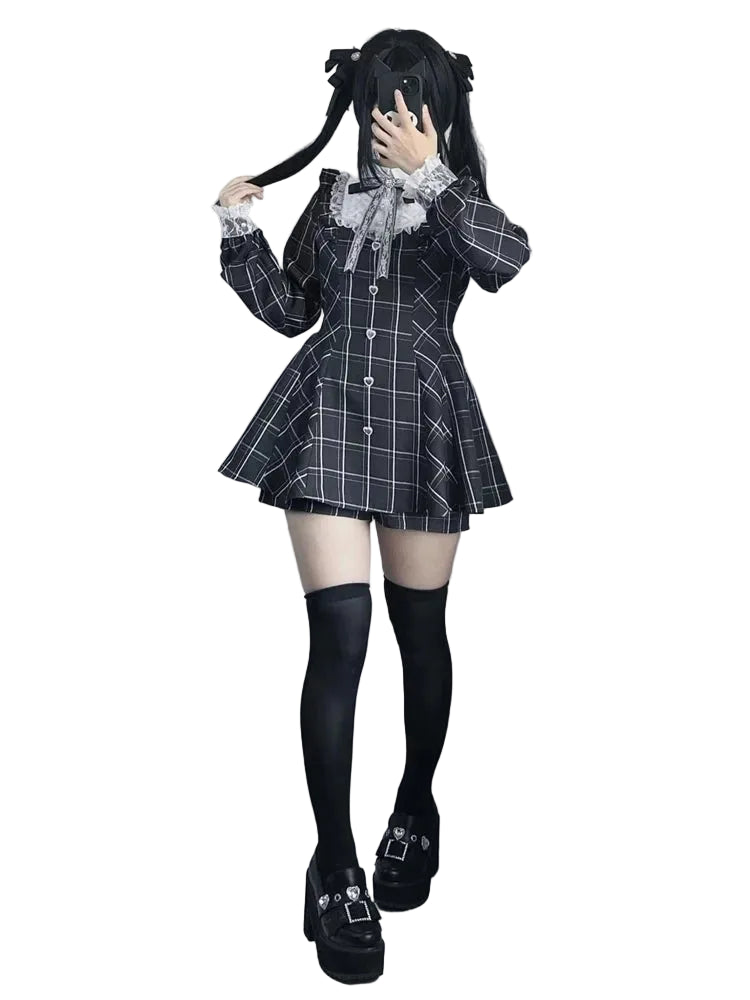 A person modeling a black and white plaid mini dress with a large white ruffled collar, paired with black thigh-high socks and black platform shoes with silver buckle details.