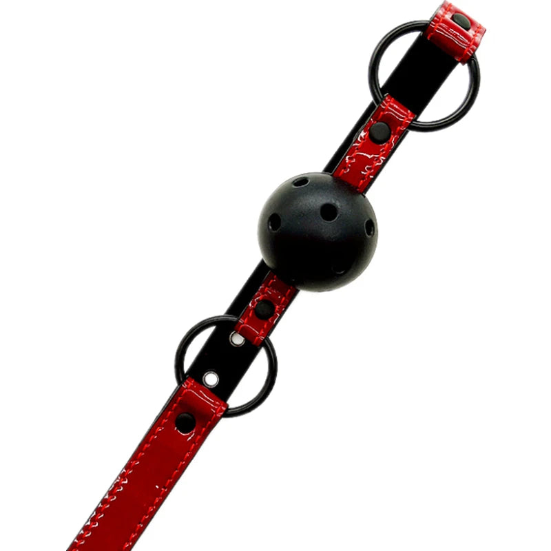Black breathable ball gag with a perforated hollow ball on an adjustable red and black PU leather strap with O-rings and buckle.