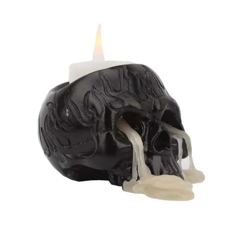 A black skull candle molded with a raised flame texture across the crown.
