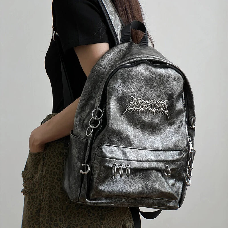 A black Y2K gothic PU leather backpack with metal ring hardware and large capacity, shown against a plain white background.