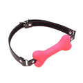 Pink silicone bone-shaped gag on an adjustable black PU leather strap with red stitching and a metal buckle.