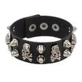 Black PU leather cuff with silver skull-and-crossbones studs alternating with cone spikes.