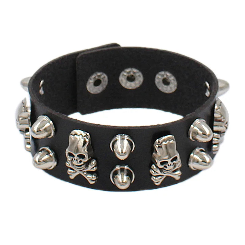 Black PU leather cuff with silver skull-and-crossbones studs alternating with cone spikes.