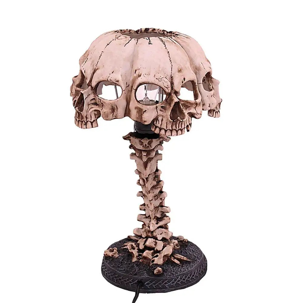 Resin table lamp with a dome shade sculpted from four joined skulls that let the light spill out through the eye sockets.