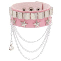 Pink PU leather cuff with a row of silver pyramid studs and a row of silver stars, finished with draped silver chains and a small bell charm.