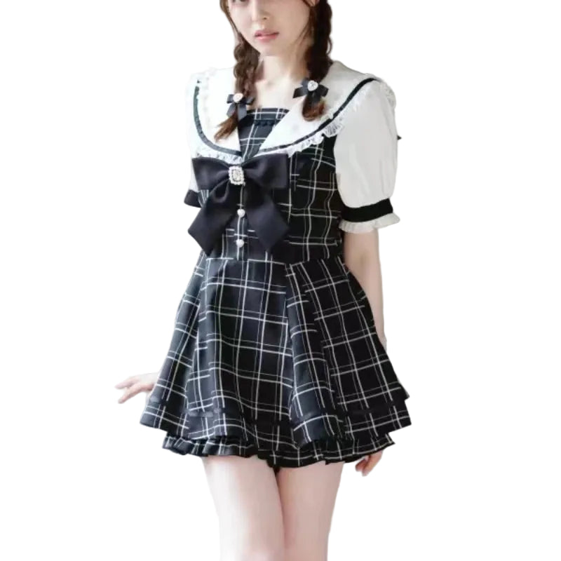 A young woman wearing a short black and white plaid dress with a white collar, black bow, and lace trim.