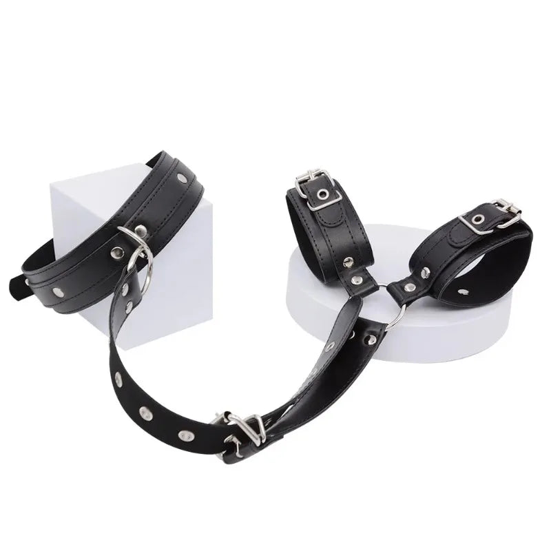A black bondage restraint kit including a silicone mouth gag, wrist cuffs, and collar, shown against a plain white background.