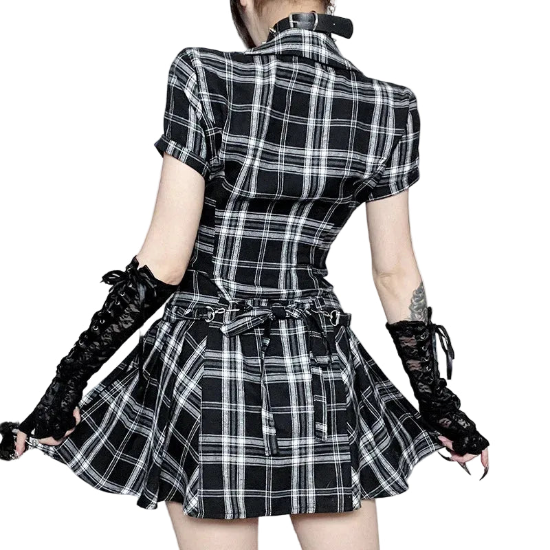 Person wearing a black and white plaid dress with lace gloves in an elegant setting.