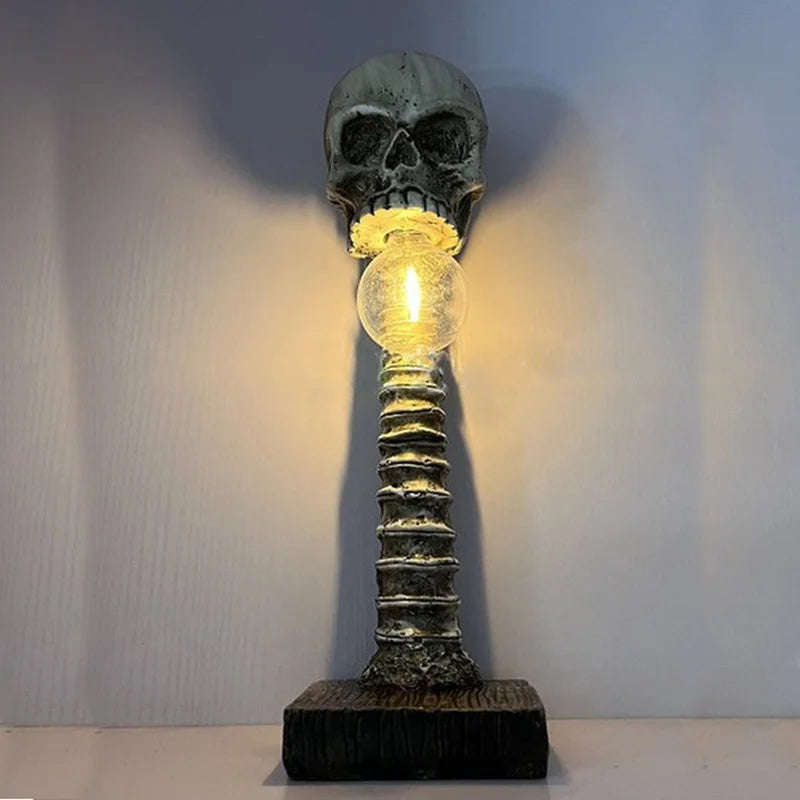 Skull-shaped lamp with glowing bulb against a plain background